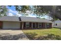 Inviting single-story brick home with a two-car garage and a manicured front lawn at 1223 Lawrence Ave, Deltona, FL 32725
