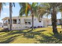 Exterior view of home with a deck, front lawn, and tropical landscaping at 906 Beechwood Ave, Lady Lake, FL 32159