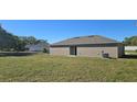 Expansive backyard featuring an AC unit and sliding glass doors, providing ample outdoor space and natural light at 521 Cardinal Dr, Poinciana, FL 34759