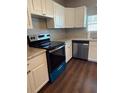 Well-lit kitchen with white cabinets, stainless steel dishwasher, oven, and speckled countertops at 3123 Crystal Hills Dr, Lakeland, FL 33801
