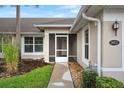 Inviting entryway features a screened-in porch and well-maintained landscaping at 26922 White Plains Way, Leesburg, FL 34748