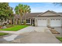 Beautiful home exterior features a well-manicured lawn, landscaping, and attached two-car garage at 26922 White Plains Way, Leesburg, FL 34748
