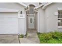 Front door with oval window and an arched window above, located next to the garage at 580 Tree Shore Dr, Orlando, FL 32825