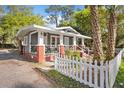 Quaint single-story home featuring gray siding, red brick accents, and a charming white picket fence at 1309 Sanford Ave, Sanford, FL 32771