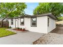 Side view of a modern, white, single-story home with a well-kept lawn and driveway at 760 S Park Ave, Winter Garden, FL 34787