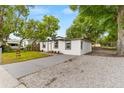Side view of a modern, white, single-story home with a well-kept lawn and driveway at 760 S Park Ave, Winter Garden, FL 34787