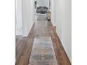 Bright hallway featuring hardwood floors and a decorative rug leading to a cozy living room at 540 Glade Ct, Kissimmee, FL 34758