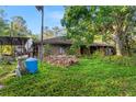 Outside view of a brick house with a covered carport and overgrown greenery at 1915 Poinsettia Dr, Port Orange, FL 32128