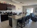 Features a modern kitchen with stainless steel appliances and a granite countertop island with barstool seating at 308 Aberdeen Dr, Davenport, FL 33896