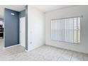 Bright living room features neutral tile flooring, a front door, and a large window with natural light at 3514 Yacht Club Ct, Kissimmee, FL 34746