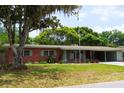 Beautiful single story brick home with well-manicured lawn and mature trees at 5801 Poinciana Ave, Lakeland, FL 33809