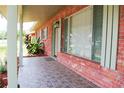 Inviting front porch with stylish tile, brick accents and views of the surrounding landscape at 5801 Poinciana Ave, Lakeland, FL 33809