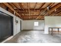 Spacious basement with exposed wooden beams, concrete floor, and a utility sink, ready for customization at 760 Formosa Ave, Bartow, FL 33830