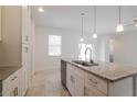 Close up on kitchen island featuring granite countertops, stainless steel appliances, and white cabinetry at 421 Arkansas Ct, Poinciana, FL 34759