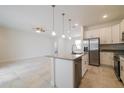Bright kitchen featuring white cabinets, stainless steel appliances, and granite countertops overlooking living area at 421 Arkansas Ct, Poinciana, FL 34759
