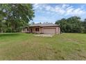 View of the front of the home showing its front porch and large, green yard at 18829 Starry St, Orlando, FL 32833