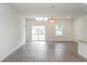 Bright living space with wood floors, neutral walls and a sliding glass door to the backyard at 13 Haddock Way, Poinciana, FL 34759