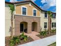 Charming multi-level townhome features landscaped front yard and covered entryway at 8882 Geneve Ct, Kissimmee, FL 34747