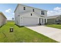 Two-story home with a two car garage, green lawn, and visible utility boxes on the side of the house at 2222 Oklahoma Dr, Sumterville, FL 33585