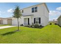 Well maintained two-story home with a green lawn, a tree, and a two car garage at 2222 Oklahoma Dr, Sumterville, FL 33585