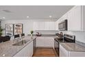 Well-equipped kitchen featuring granite counter tops, stainless appliances, and wood look flooring at 2383 Oklahoma Dr, Sumterville, FL 33585