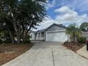 A single-Gathering home with a long driveway flanked by mature trees and landscape at 1152 Mccormick Dr, Deltona, FL 32725
