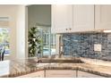 Modern kitchen with granite countertops and stainless steel sink, overlooking pool at 3 Seabridge Dr, Ormond Beach, FL 32176