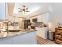 Bright kitchen featuring white cabinets, granite countertops, stainless steel appliances, and modern finishes at 3 Seabridge Dr, Ormond Beach, FL 32176
