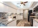 Modern kitchen with granite countertops, white cabinets and stainless steel appliances at 3 Seabridge Dr, Ormond Beach, FL 32176