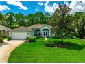 Well-manicured front yard with lush green lawn and mature landscaping complements the inviting exterior of this charming home at 1273 Sunningdale Ln, Ormond Beach, FL 32174