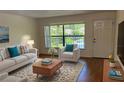 Stylish living room with modern furnishings, beautiful rug, and plenty of natural light from the large window at 108 Lacosta Ln # 621, Daytona Beach, FL 32114