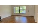 Spacious living room featuring hardwood floors and abundant natural light from the large front window at 108 Lacosta Ln # 621, Daytona Beach, FL 32114