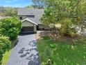 A well maintained house featuring a large driveway, a two-car garage, and mature trees in a lush yard at 100 Longspur Ct, Daytona Beach, FL 32119