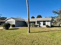 Well-maintained single-story home featuring a lush green lawn and meticulously trimmed shrubs on a clear day at 305 American Way, Daytona Beach, FL 32119