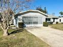 Charming single-story home with a screened in garage, neat landscaping and a spacious driveway at 305 American Way, Daytona Beach, FL 32119