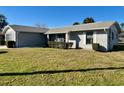 Inviting single-story home with a neatly manicured lawn and classic white shutters, showcasing curb appeal at 305 American Way, Daytona Beach, FL 32119