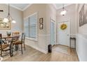 Bright entryway with wood-look floors, white door, and window with shutters at 3242 Bailey Ann Dr, Ormond Beach, FL 32174