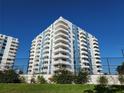 Low angle shows a condominium building featuring white balconies with blue accents, secured by a black fence at 935 N Halifax Ave # 602, Daytona Beach, FL 32118