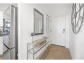 Bright condo entryway with glass-top console table and mirror at 1 Oceans West Blvd # 16A4, Daytona Beach, FL 32118