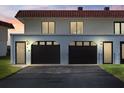 Townhouse garage features two bays, dark doors, white trim, and red tile roof at 41 Ocean Palm Villa S # 41, Flagler Beach, FL 32136