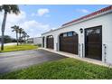 Two-car garage with dark brown doors and a paved driveway, side view at 41 Ocean Palm Villa S # 41, Flagler Beach, FL 32136