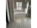 Bathroom with a garden tub, shower, and marble tile flooring at 130 Prima Dr, Kissimmee, FL 34759