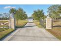 Long driveway leading to house with stone pillars and lion statues at 1045 Carter Rd, Deland, FL 32724