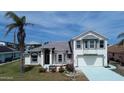 Charming home featuring a well-manicured lawn, an attached two car garage, and neutral exterior paint with green trim at 105 Barrier Isle Dr, Ormond Beach, FL 32176