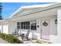 Inviting front porch with rocking chairs and pink door at 35 Country Club Dr, Ormond Beach, FL 32176