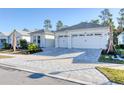 Two-story house featuring a three-car garage and a paver driveway at 707 Hang Loose Way, Daytona Beach, FL 32124