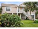 Two-story elevated beach home with palm trees and a spacious yard at 124 Avalon Dr, Ormond Beach, FL 32176