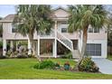 Elevated home with two-story exterior, detached garage, and landscaped yard at 124 Avalon Dr, Ormond Beach, FL 32176