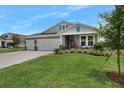 Gray two-story house with a two-car garage, landscaped yard, and a covered porch at 2840 Monaghan Dr, Ormond Beach, FL 32174