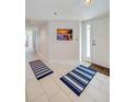 Hallway with tile floors and beach-themed wall art near the entrance at 4641 S Atlantic Ave # 2010, Port Orange, FL 32127